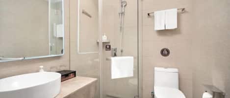 A modern bathroom with a glass-enclosed shower, a white sink, and a toilet.