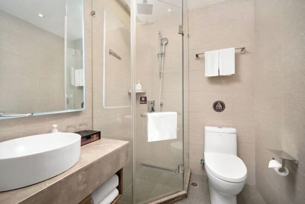 A modern bathroom with a glass-enclosed shower, a white sink, and a toilet. - HanTing Hotel (Harbin Exhibition Center Sports College) (Harbin)
