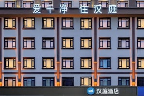 La façade d’un immeuble, ornée de nombreuses fenêtres et d’une enseigne indiquant qu’il s’agit d’un hôtel.