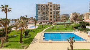 A hotel with a swimming pool, palm trees, and a well-maintained lawn. - Garceta in Benalmadena (Benalmádena)