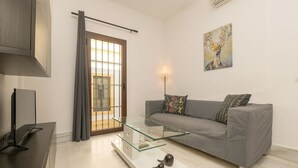 Un soggiorno moderno con un tavolino in vetro, un divano grigio e un quadro appeso al muro.