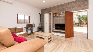 Una sala de estar moderna con sofá, una mesa de centro, chimenea y televisor.