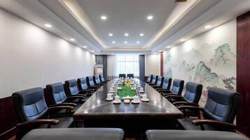 A conference room with a long table, chairs, and a decorative wall.