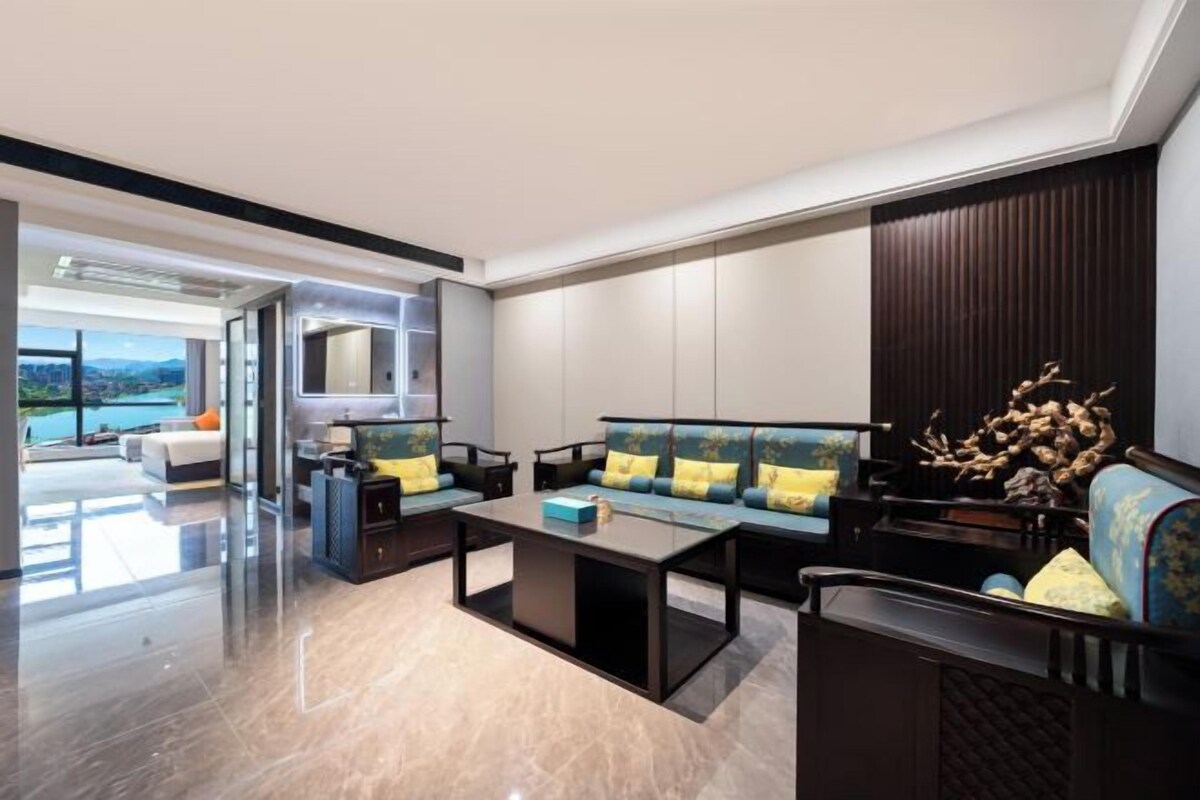 A modern living room with a sofa set, a coffee table, and a decorative plant.