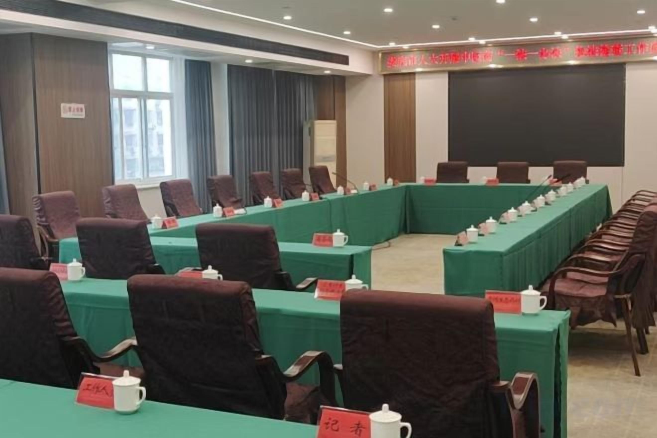 A conference room with a long table, chairs, and name placards.