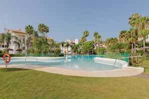 A swimming pool surrounded by palm trees and a lifeguard stand. - Calanova in Urbanizaci n Riviera Sol (Mijas)