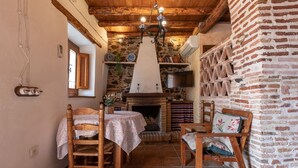 Habitació rústica amb llar de foc, mobles de fusta i parets de pedra.