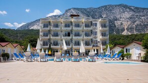 Un hôtel doté de nombreux balcons, d’une piscine et offrant une vue sur un paysage montagneux.