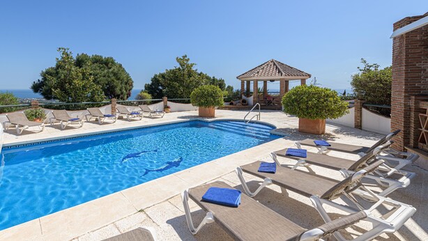 A pool area with lounge chairs and a gazebo. - Villa Lina in Estepona (Estepona)
