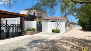 A residential street with houses, a clear sky, and a paved sidewalk. - Bay Views Near the Beach with BBQ and Balcony (El Centenario)