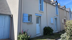 Une rangée de maisons de ville présentant un style architectural uniforme, caractérisée par une porte centrale, de petites fenêtres et une façade homogène.