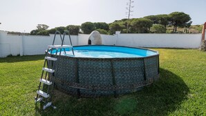 A circular swimming pool with a ladder, surrounded by a white wall and grass. - Villa Mausi in Chiclana de la Frontera (Chiclana de la Frontera)