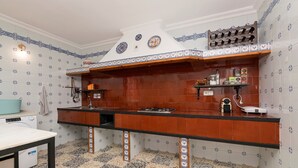 A kitchen with a tiled backsplash, a stove, and a sink. - Villa Mausi in Chiclana de la Frontera (Chiclana de la Frontera)
