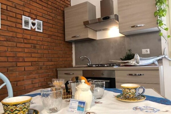 Una cocina con pared de ladrillo, muebles de cocina modernos y una escultura decorativa de pez.