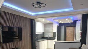 A modern living room with a flat-screen TV, a fireplace, a sofa, and a coffee table. - Enjoyable 3-bedroom house with WiFi in Watford central / 30min to Central London (Watford)