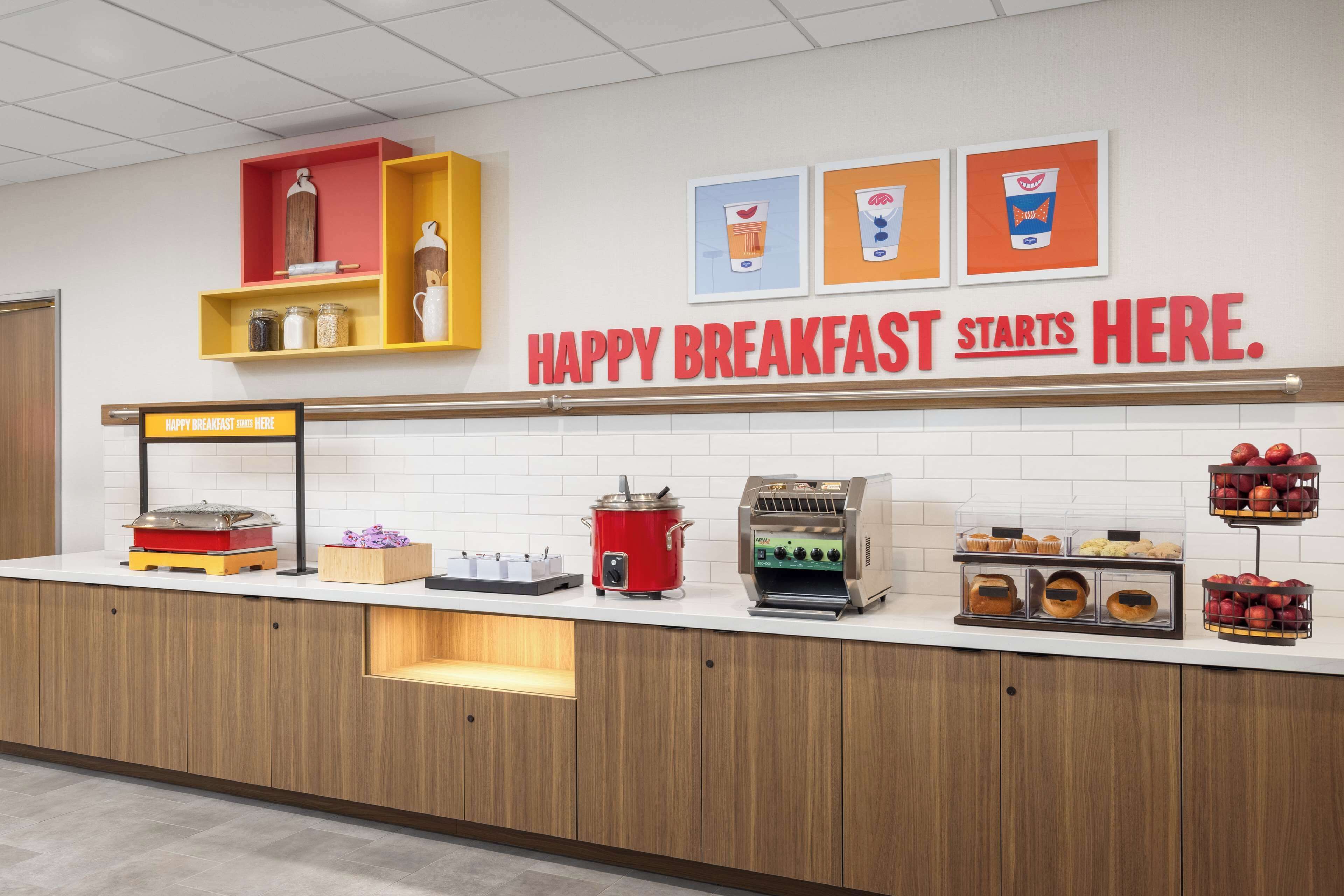 Een ontbijtbuffet met een bord waarop staat: 'HAPIG ONTBIJT START HIER'.