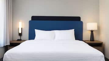 Ein Hotelzimmer mit einem großen Bett, zwei Nachttischen und einer Lampe.