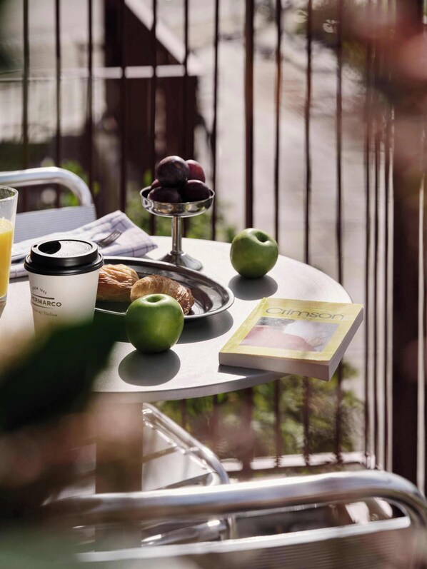 A table with a croissant, a book titled 'Crimson', and a glass of orange juice.