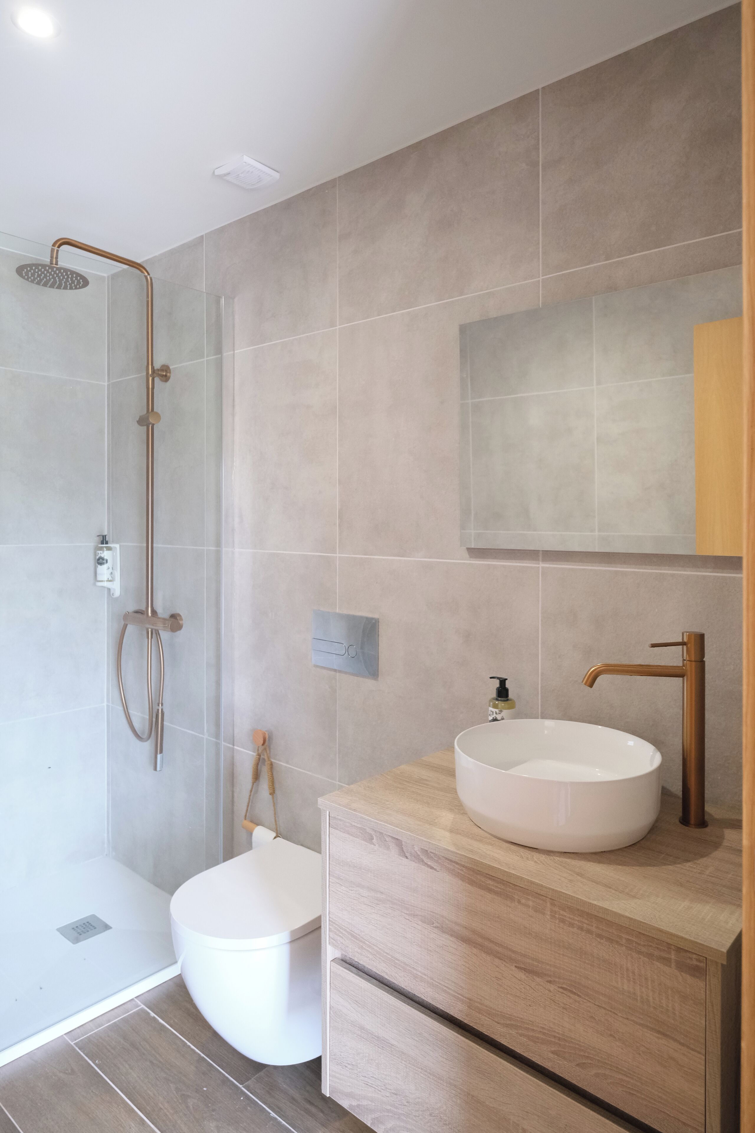 A modern bathroom with a walk-in shower, a toilet, and a vanity with a sink.