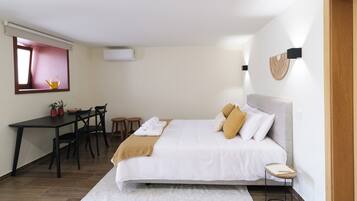 Une chambre à coucher comprenant un lit, une table de chevet et un bureau avec des chaises.