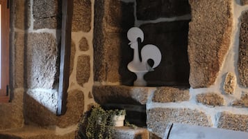 A stone wall with a fireplace, a sofa, and a decorative item.