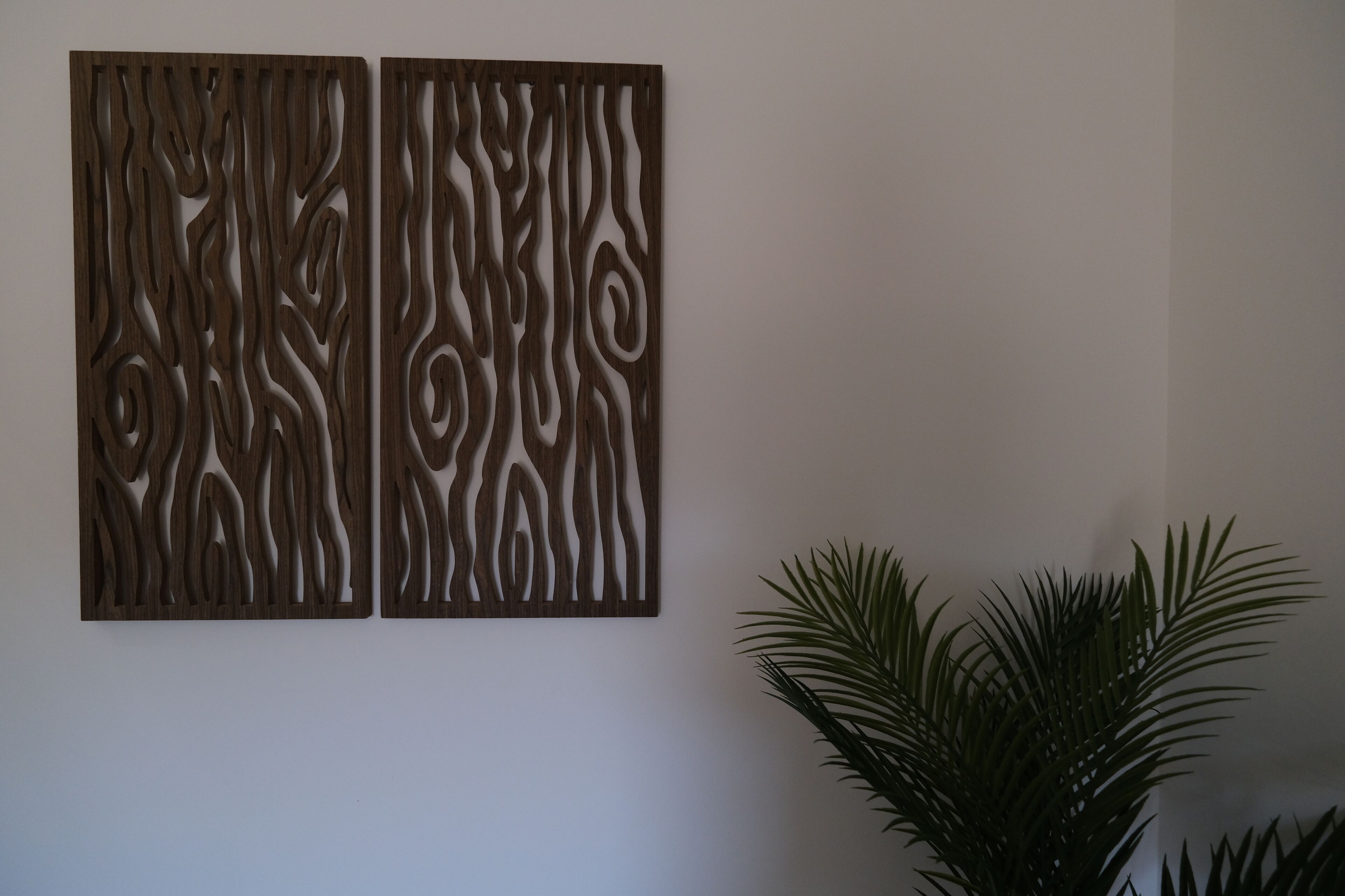 Two wooden wall panels with intricate cut-out patterns.