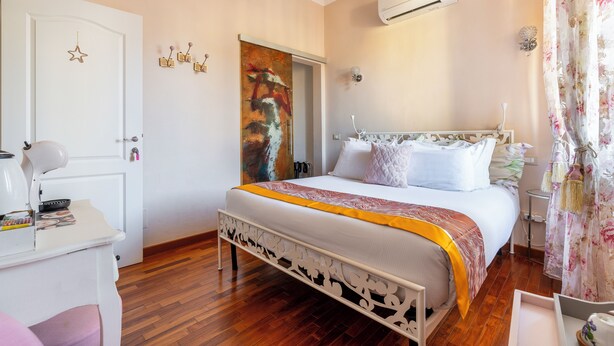 Une chambre à coucher avec un lit, une table de chevet et un bureau.