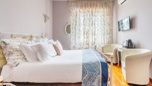 A bedroom with a bed, a chair, a desk, a mirror, and a television. - Marty Violet - Milù Holidays Firenze
 (Firenze)