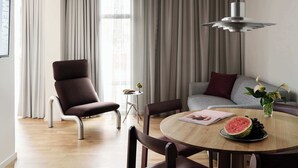 Uma sala de estar moderna com uma mesa de jantar redonda, um sofá e uma poltrona.