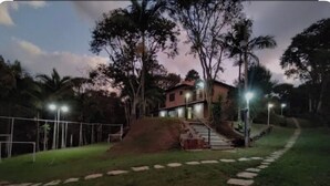 Ein Haus mit einer Treppe, die zum Eingang führt, umgeben von einem Zaun und Bäumen.