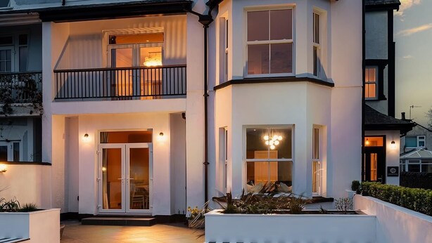 A two-story house with a balcony, a front door, and a driveway with a checkered pattern. - Camellia House, indulge in luxury at our Victorian gem in the heart of Abersoch! (Pwllheli)