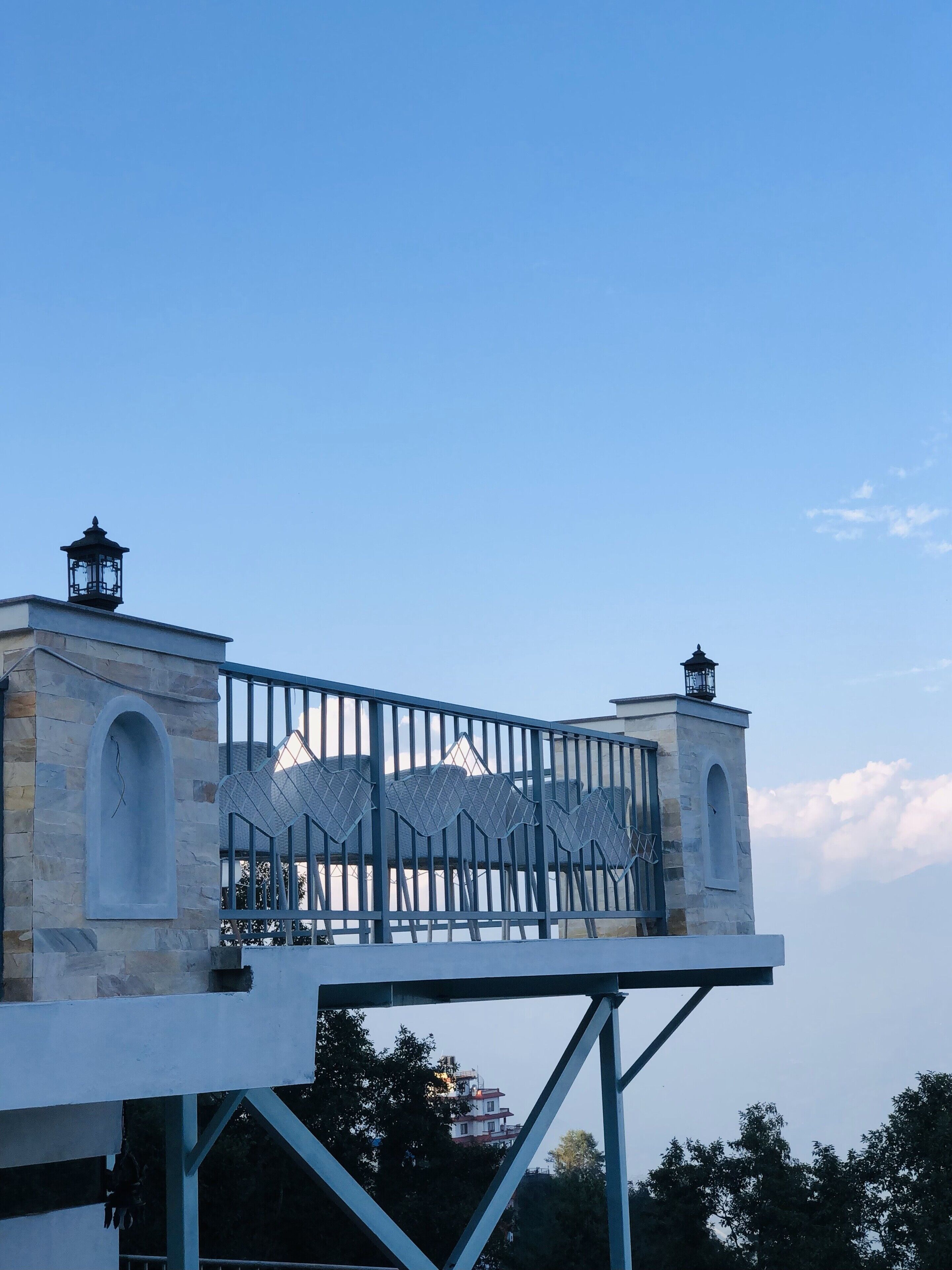 Un bâtiment à la façade en pierre, surmonté de deux lanternes et doté d’une balustrade en métal.