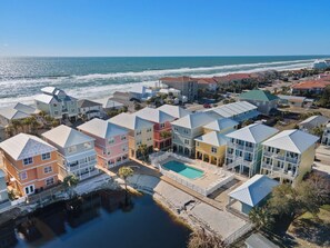 A coastal residential area with colorful houses, a swimming pool, and a view of the ocean. - Modern House with Pool Access (Panama City Beach)