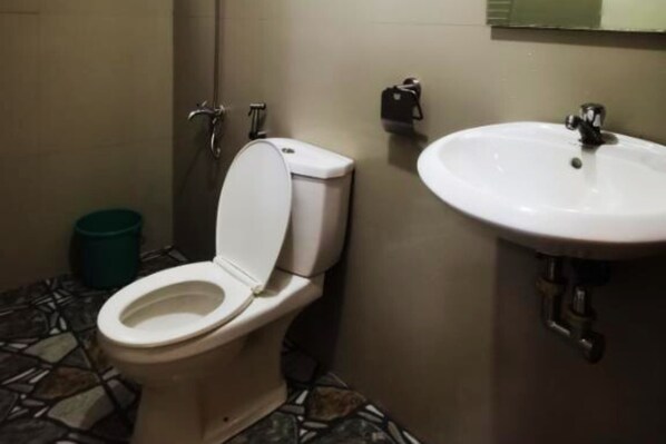 A bathroom with a toilet, sink, and tiled floor. - Viewscape Nature Park Tanay powered by Cocotel (Tanay)