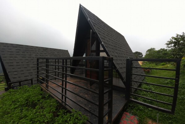 A modern building with a sloped roof and a metal fence surrounding the entrance.