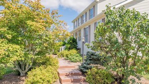 A two-story house with a covered porch and a brick pathway leading to the front door. - Mountain View Escape (Christiansburg)
