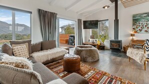 Un salón amplio con un ventanal grande, una chimenea y un televisor.