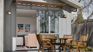A modern house with a patio area featuring wooden furniture and a pergola. - Amazing Location! Central 2 bedroom Unit (Wānaka)
