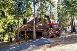 Exterior - Tucked in the trees, Cedar Hill is a cozy A-frame cabin with modern updates, a spacious kitchen, wraparound deck, and stunning views. The perfect mountain escape for families, couples, and friends—plus, it's pet-friendly! (Shaver Lake)