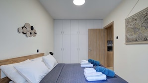 Un dormitorio con una cama, cortinas blancas, un armario de madera y un mapa en la pared.