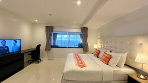 A hotel room with a bed, a desk, a television, and a window with curtains. - A11 - 2 Bdr Condo, Stunning Sea View, Karon Beach (Karon)