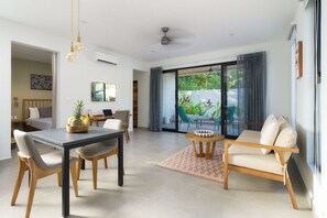 Un salon moderne comprenant un coin repas, un canapé et une table avec des chaises.