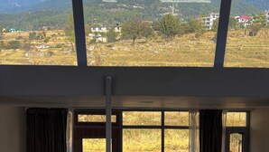 A room with a large window overlooking a mountainous landscape.