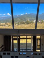 A room with a large window overlooking a mountainous landscape.