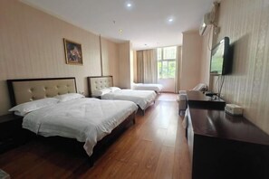 A hotel room with three beds, a desk, a TV, and a window. - Haidian Resort Hotel (Beihai)