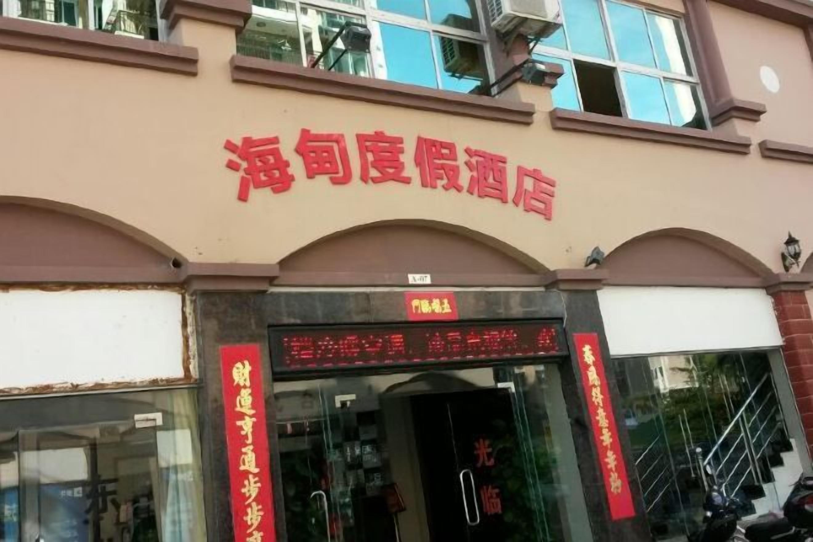 A hotel entrance with a signboard and a staircase leading up to the entrance.