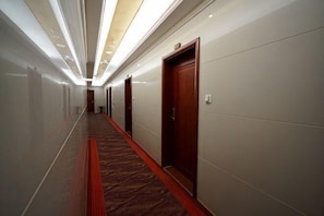 A long, narrow hotel corridor with doors on one side and a carpeted floor. - Haidian Resort Hotel (Beihai)