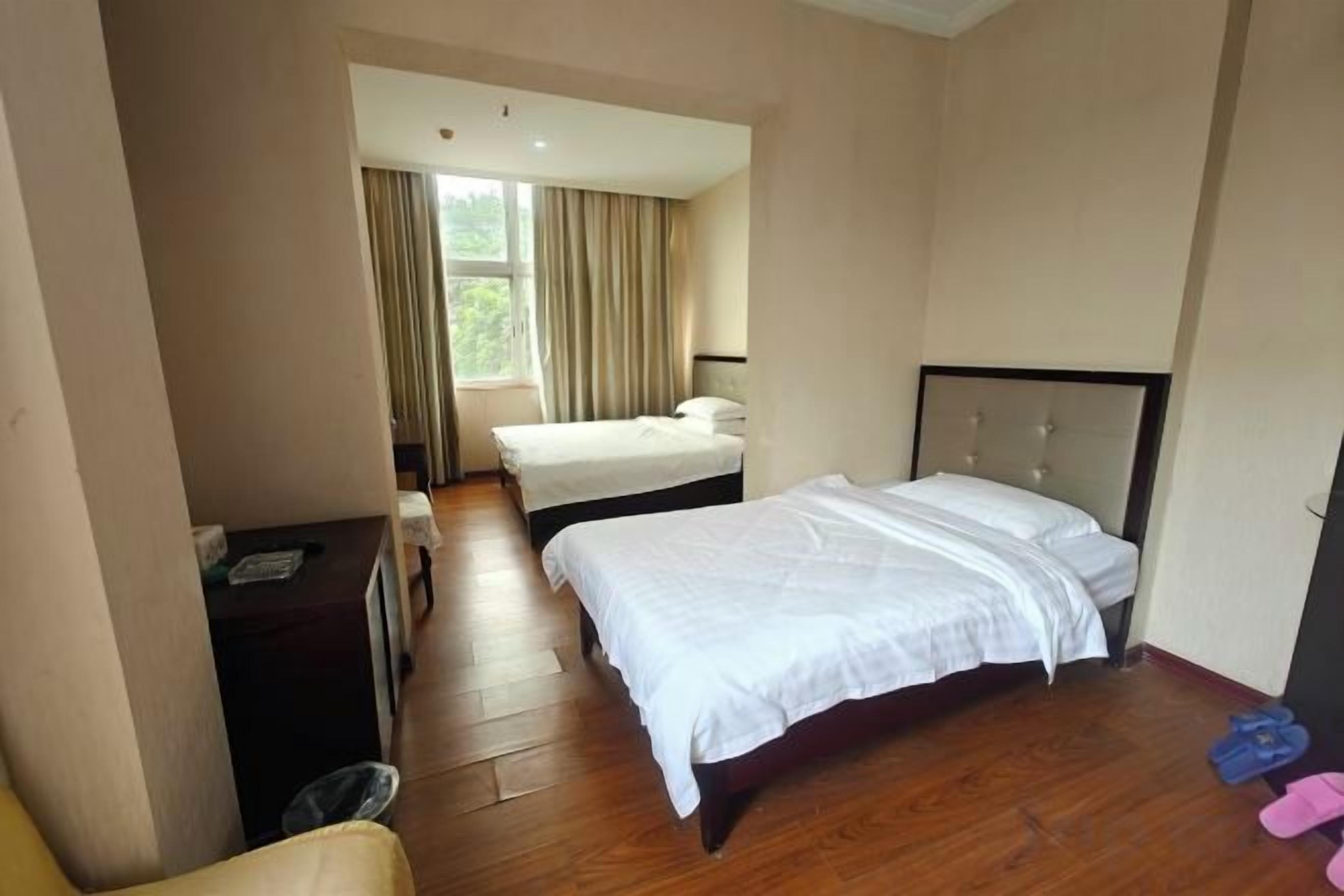 A hotel room with a bed, a desk, and a chair.