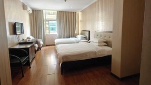A hotel room with two beds, a desk, a chair, a TV, and a window with curtains. - Haidian Resort Hotel (Beihai)