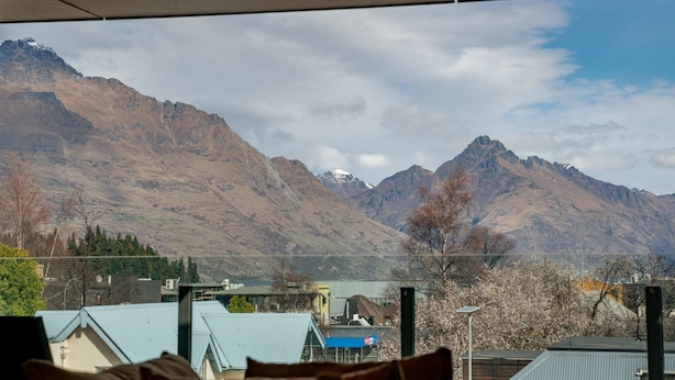 Un paisaje montañoso con una vista de un pueblo en primer plano.